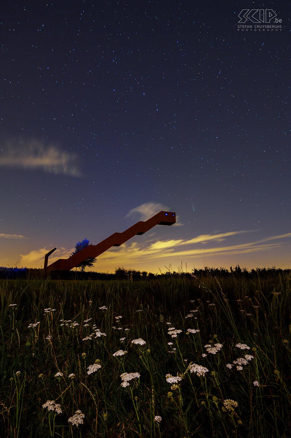 Hageland by night - Vlooybergtower in Tielt-Winge with comet NEOWISE In the summer of 2020 we could observe comet NEOWISE on Earth. The Vlooybergtower in Tielt-Winge seemed like a great location to capture the comet on picture. The comet with its luminous tail can be seen to the right of the top of the stairs. The pictures were taken between 11:30 pm and midnight. Since May 2015 an eye-catching structure has been built in Tielt-Winge. It blurs the distinction between a tower and a stairway and it floats high above the Kabouterbos. Stefan Cruysberghs